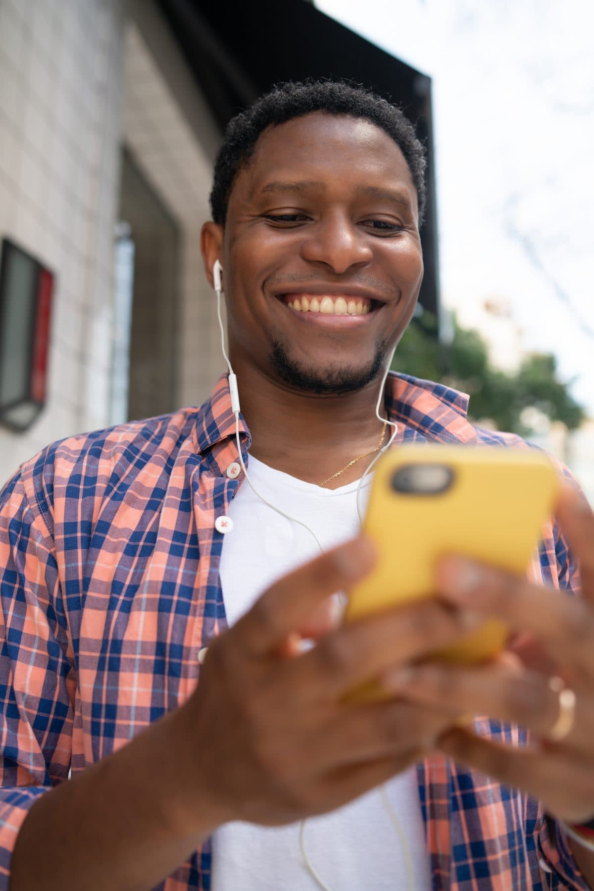 Man in a plaid shirt checking his Dolo app on his phone